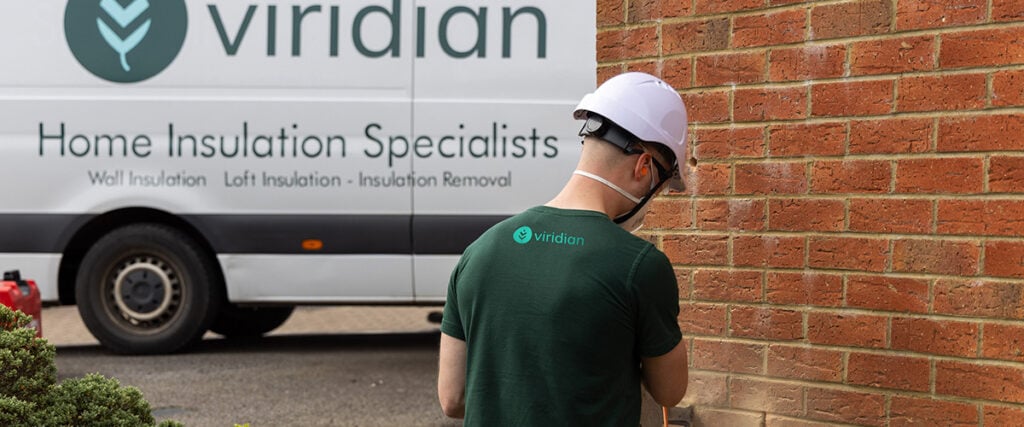 Man cutting out a brick for access to carry out cavity wall insulation removal and cleaning.
